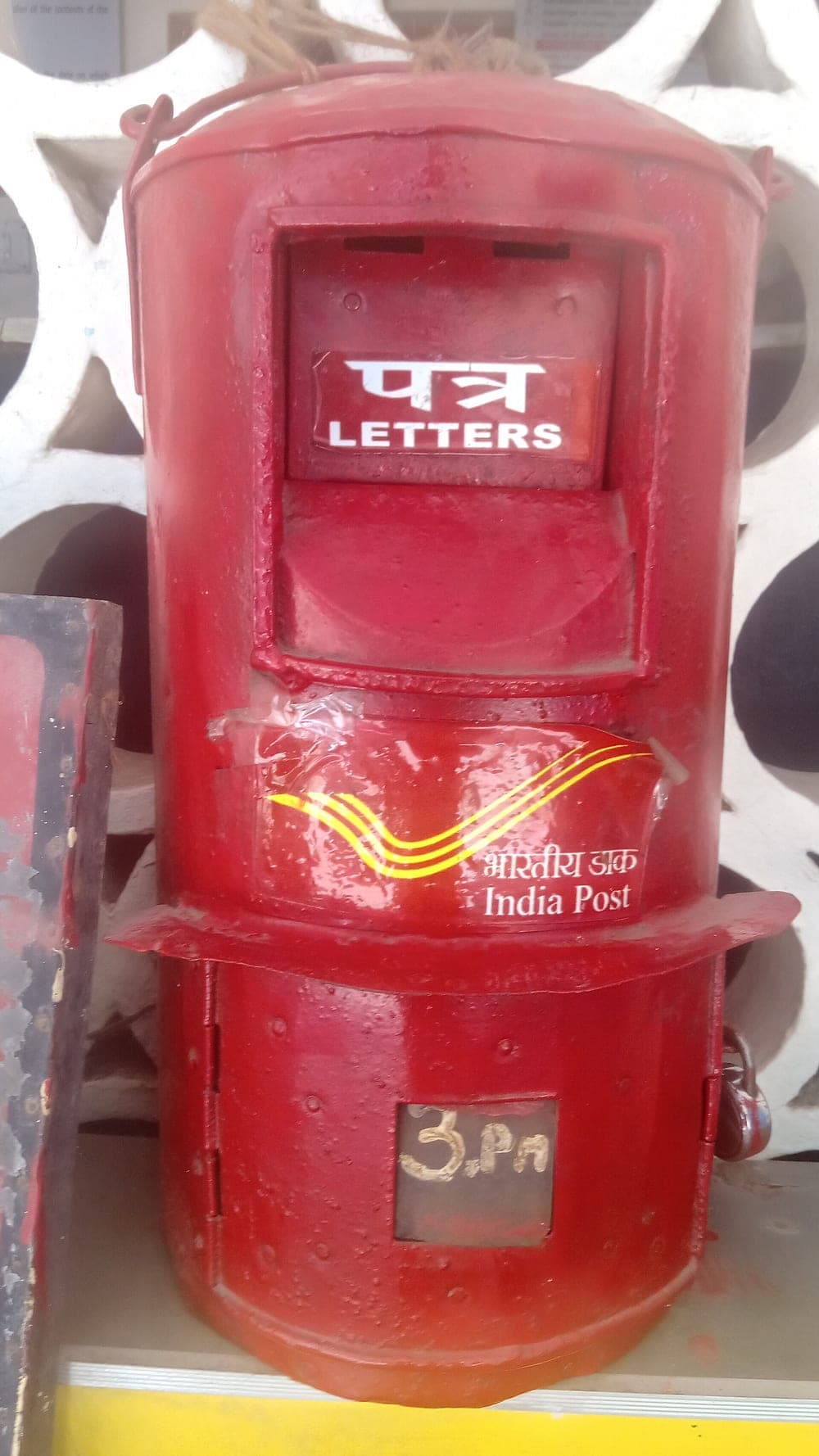 A red India Post letter box marked पत्र, letters