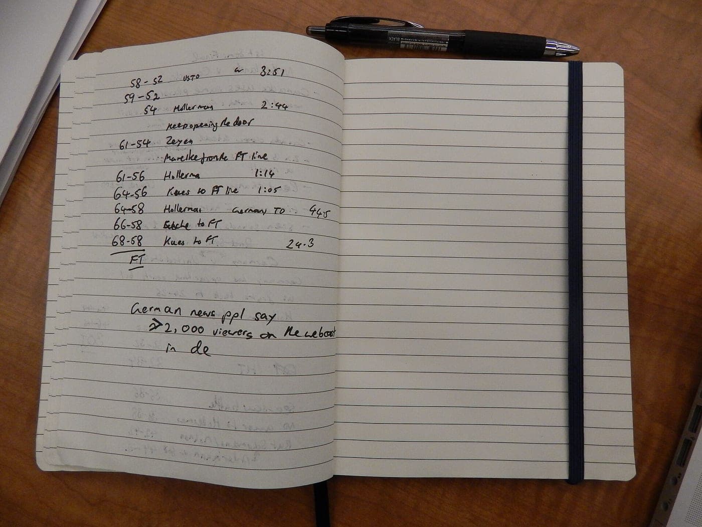 A reporter's notebook open on a desk, with a pen