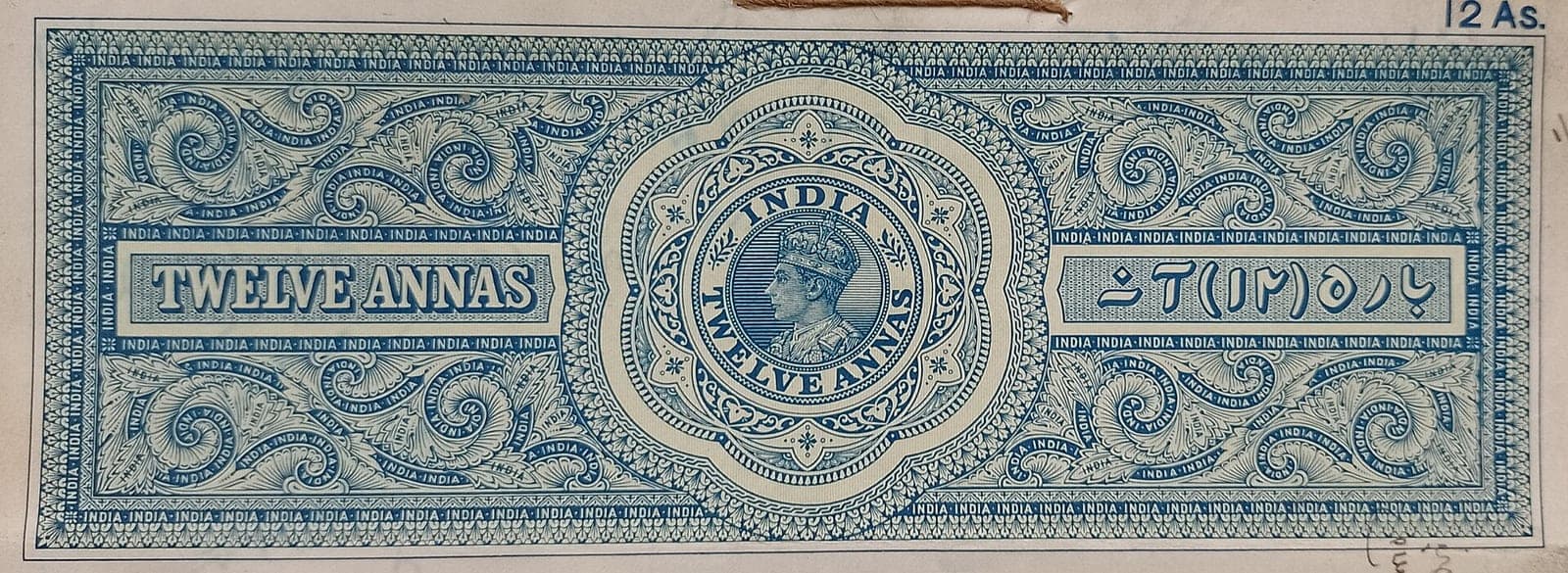 The top of a twelve-anna stamp paper from British India